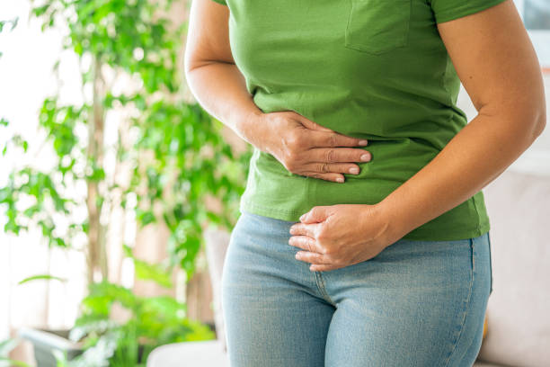 femme touchant son estomac ressentant des douleurs abdominales à la maison - digestive issues photos et images de collection